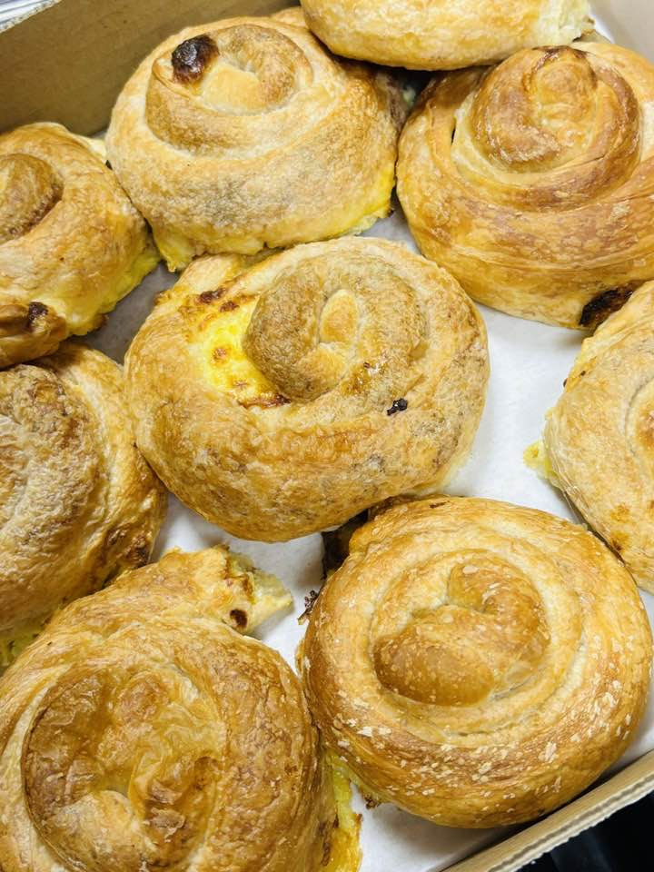 Box of individual sirnica cheese-filled coiled pastries