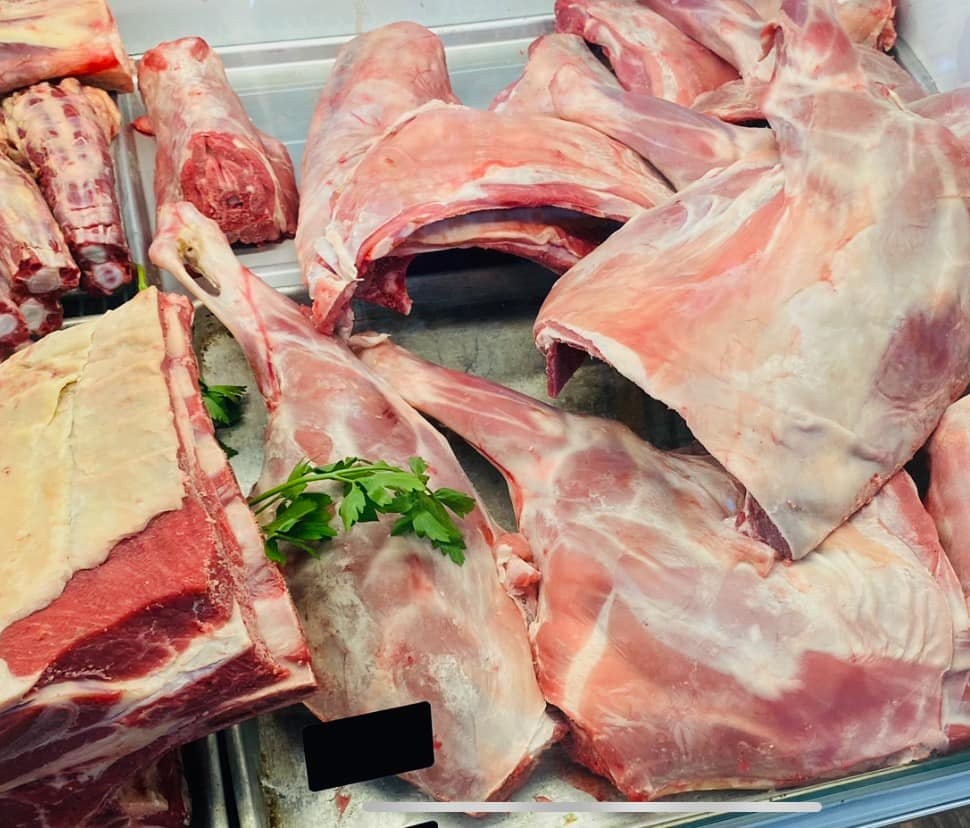 Assorted fresh lamb and beef cuts arranged in the display case for a bulk freezer order