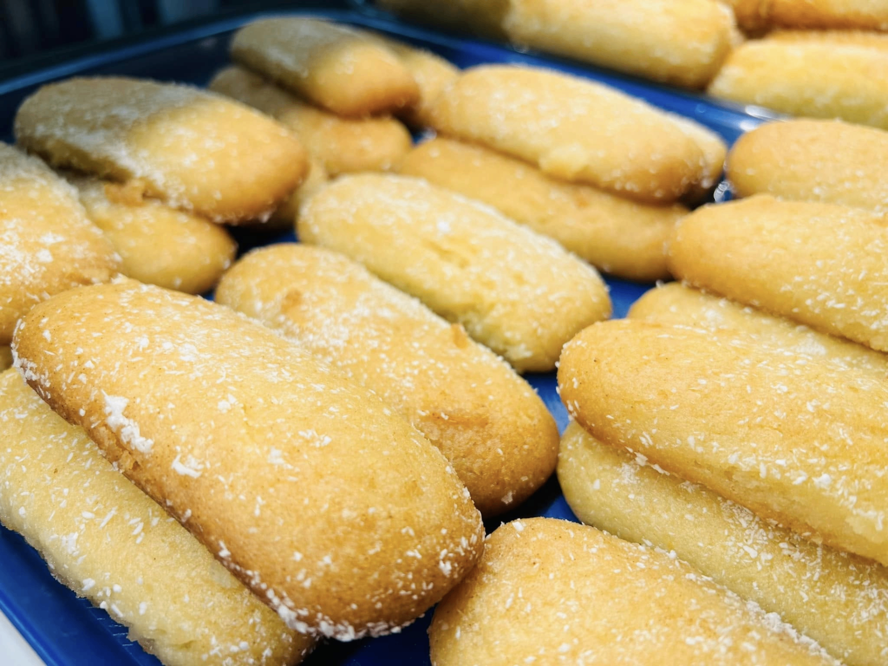 Tray of golden hurmašice semolina cookies dusted with coconut