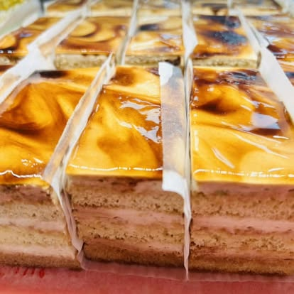 Caramel-glazed layered cake slices in the bakery case