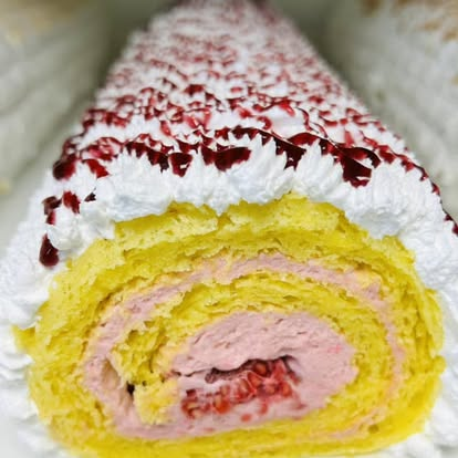 Sliced sponge roll cake with raspberry cream filling